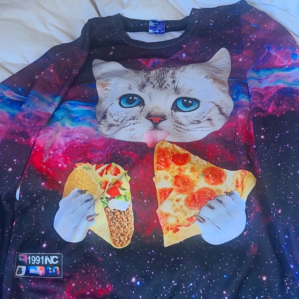 Cat eating toco and a pizza sweatshirt